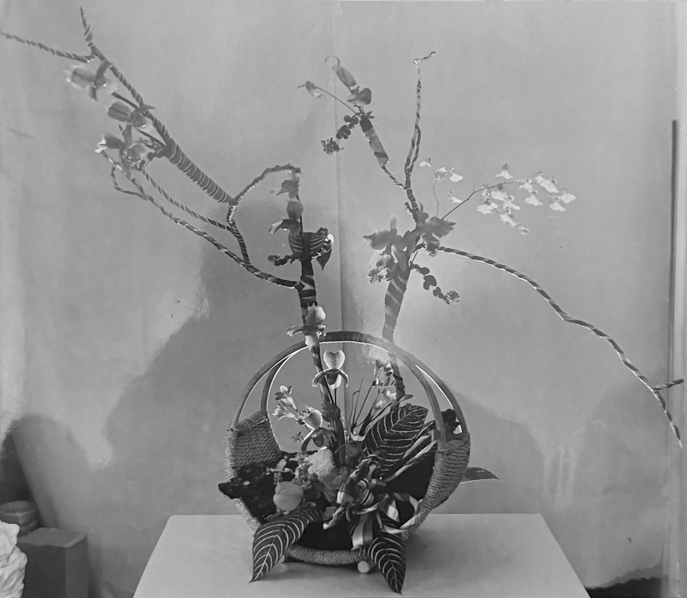 Modernt blomsterarrangemang med grenar i en korg
